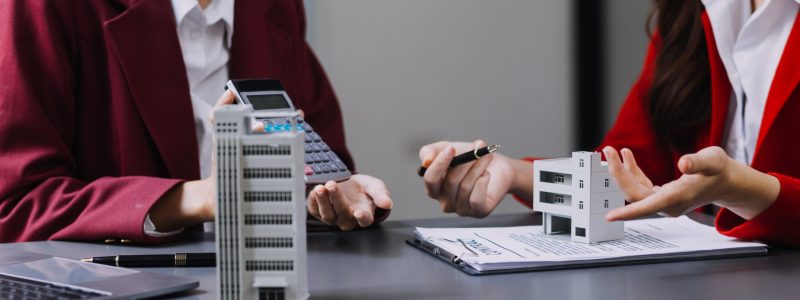 Discussion with a real estate agent, House model with agent and customer discussing for the contract to buy, get insurance or loan real estate or property.